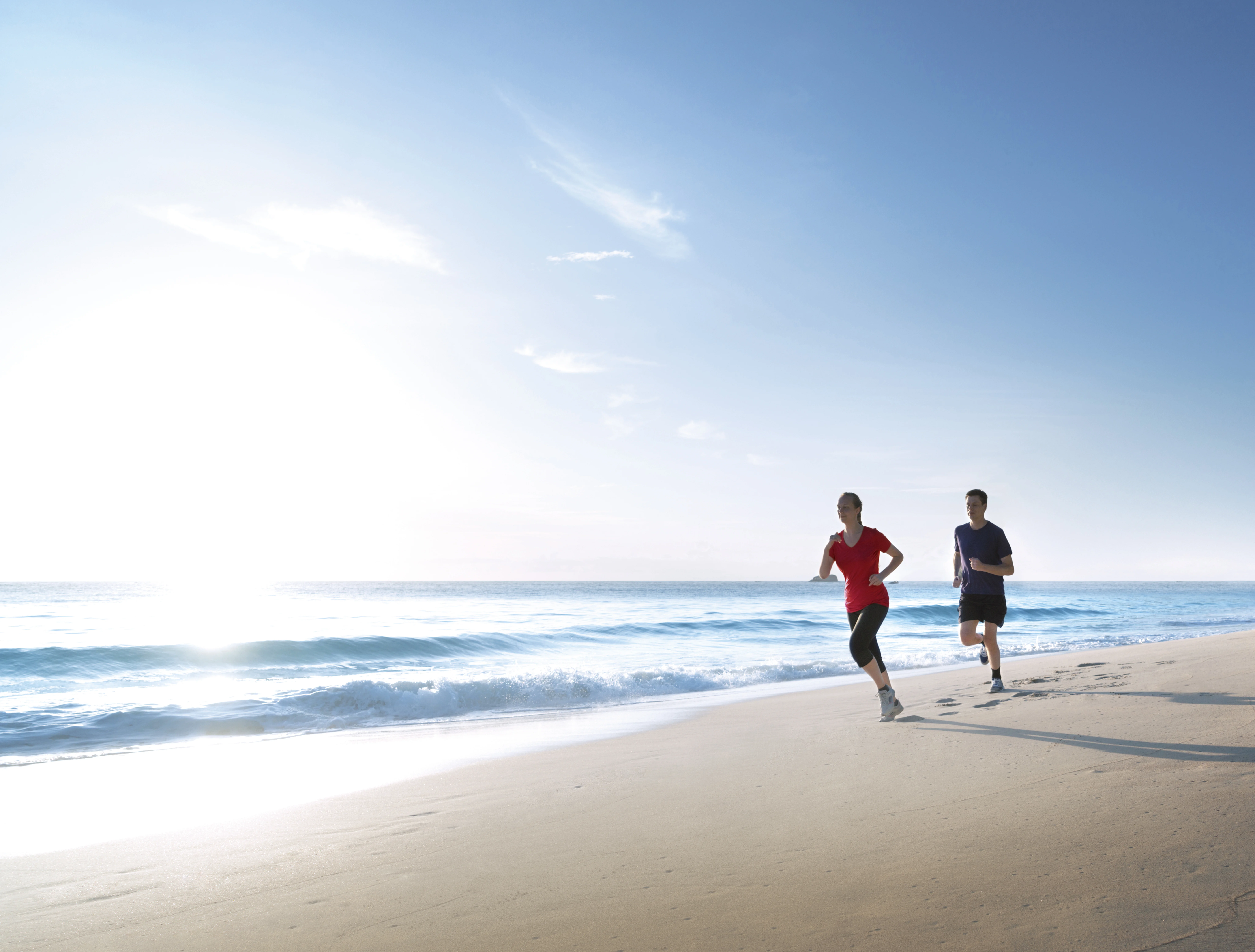 due persone che corrono su una spiaggia