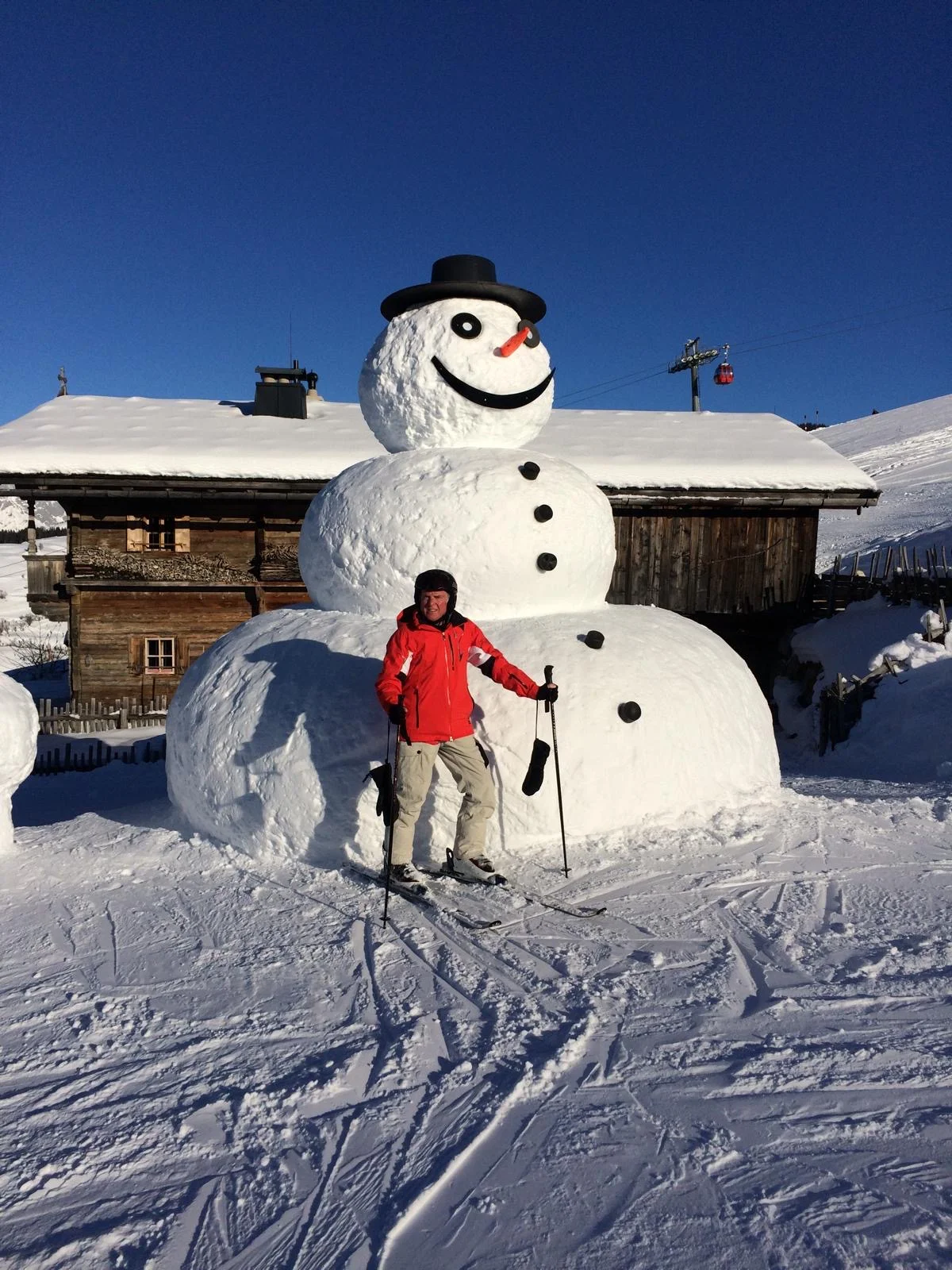 man with an ostomy posing outdoors with a large snowman