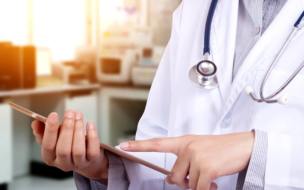 a close-up of a doctor holding a tablet